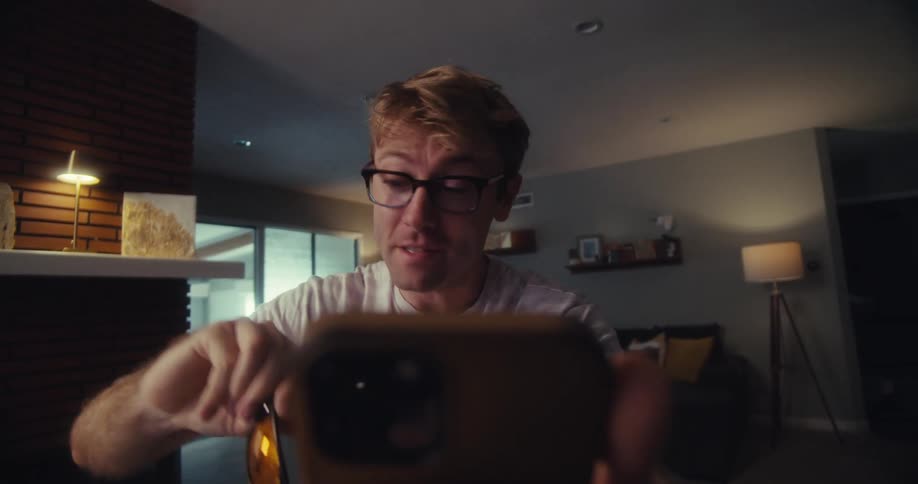 Man excitedly shows sunglasses during a video call at home