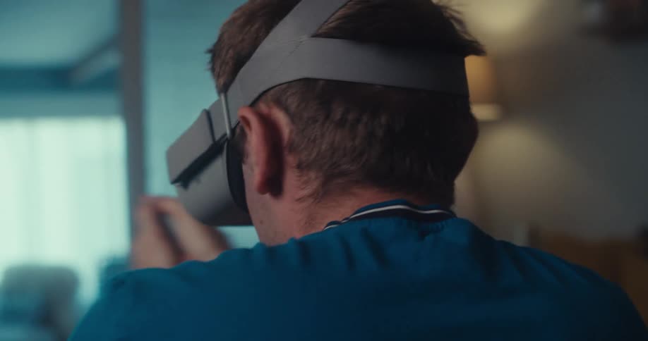 A man wearing a vr headset is playing an exciting game constantly turning around in circles while indoors