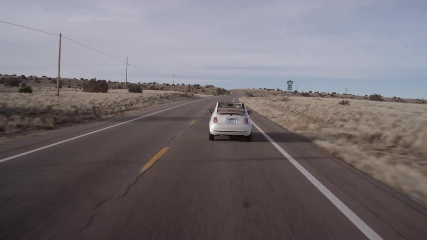 Cars drive down the road in this desert