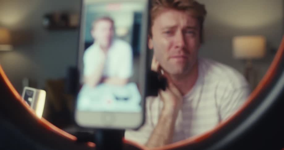 A footage of a man recording a video with a smartphone