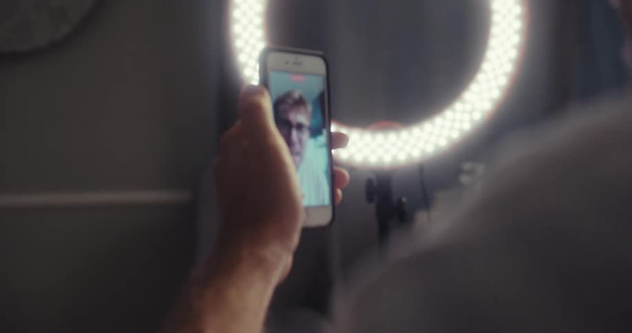 Side portrait of a man taking selfie with a smartphone