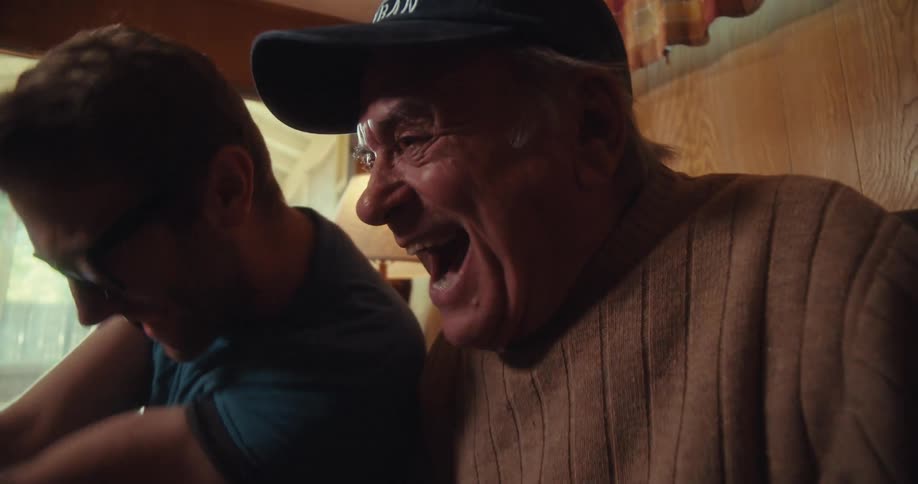 Grandfather and grandson celebrate while watching an event on a phone