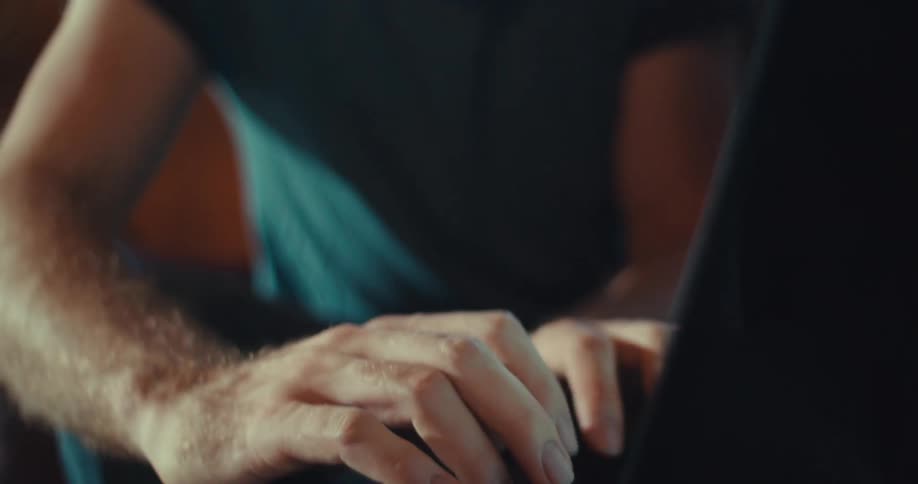 A man is talking and typing on his laptop