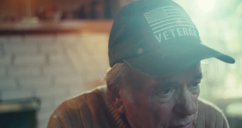 Man in a hat talking with a serious expression on his face