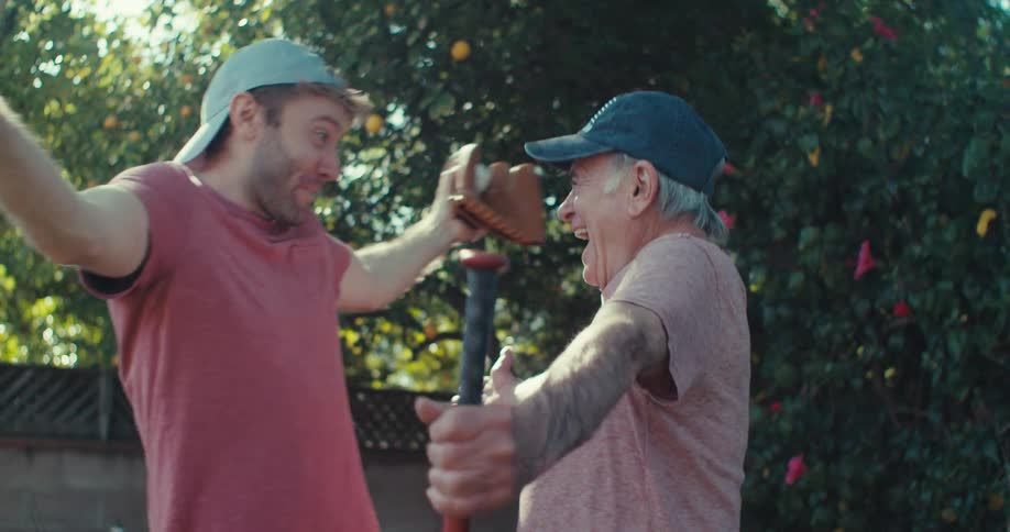 Two men hugging in a backyard with trees