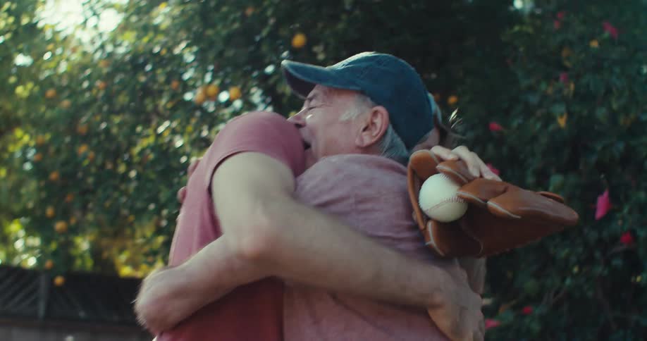 A footage of an elderly man and a young man embracing