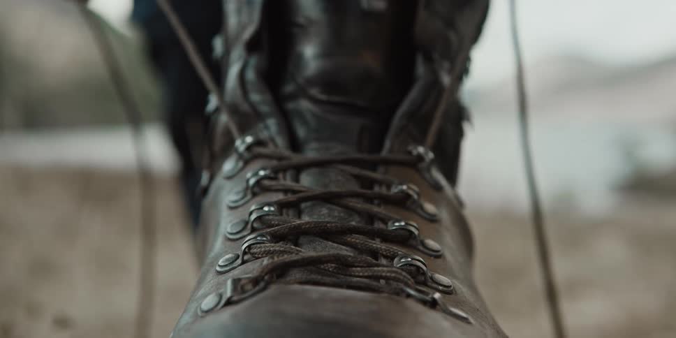 A persons fingers squeezing a boot lace to make it tight