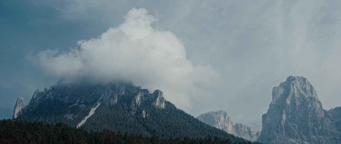 Clouds swirl over the mountain tops as it snows