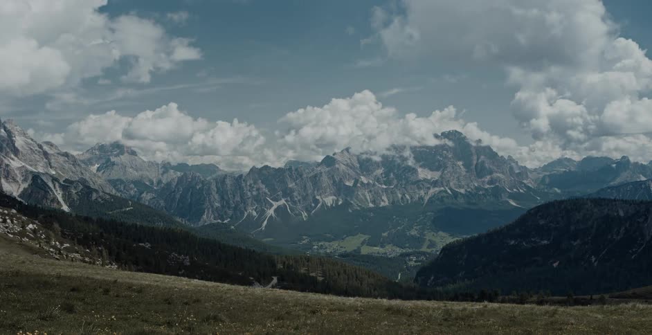 Clouds flowing across mountainous terrain cast shadows
