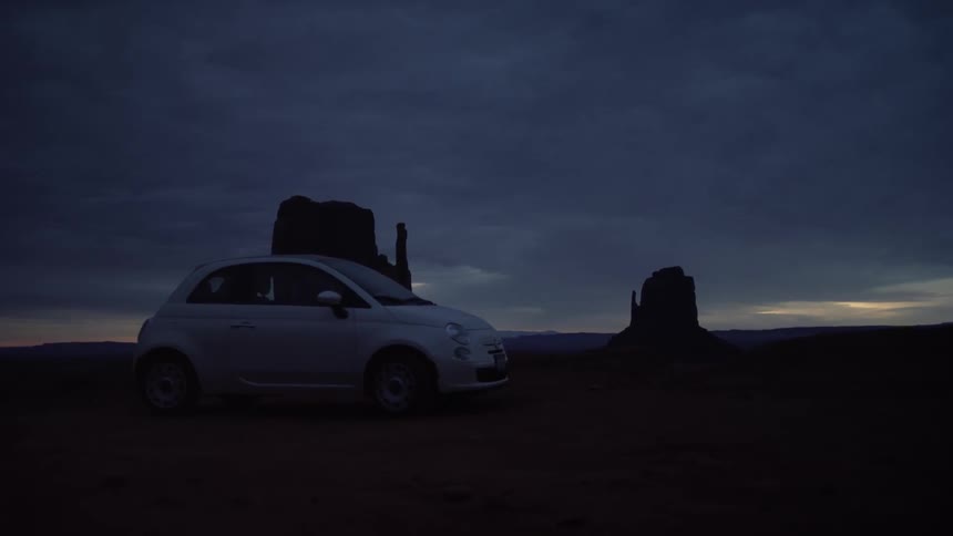A car is parked on a field at dawn