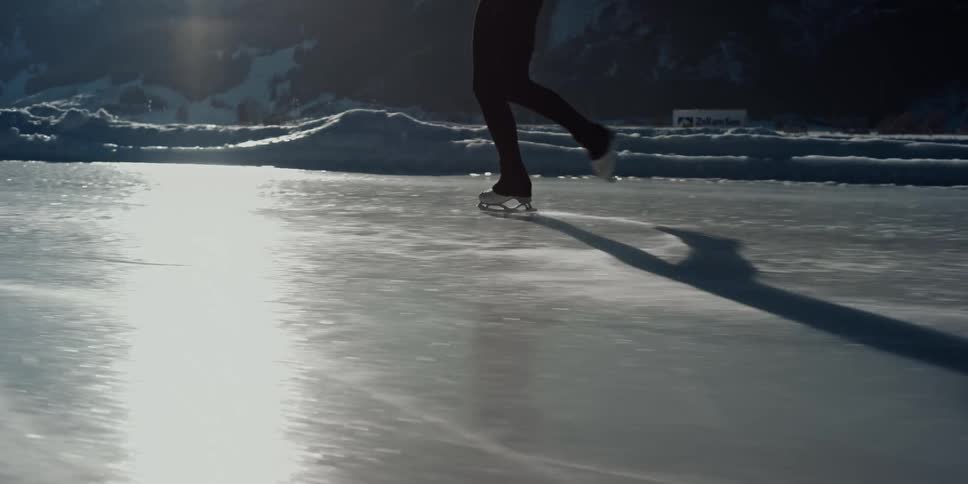 Person ice skating on a lake on a bright sunny day