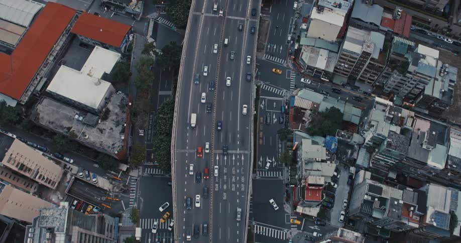Birds eye view commuters driving across a highway in dowtown metropolitan area