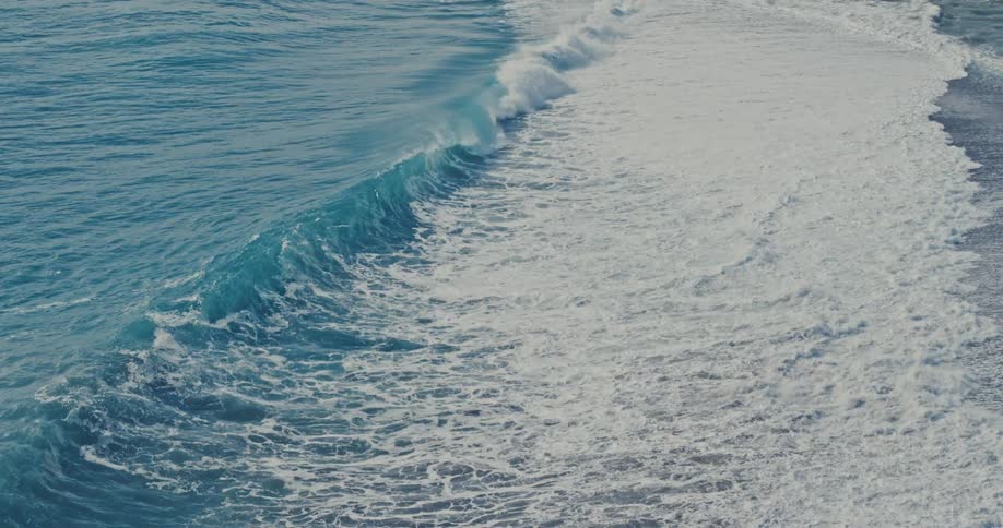 Waves rolling on the shoreline of sandy beach