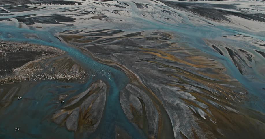 Birds fly over terrain divided by multiple streams and waterways