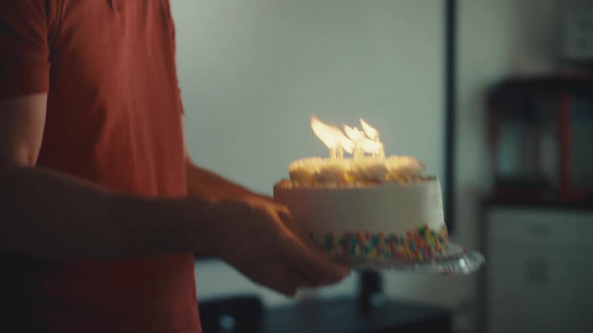 A footage of a man presenting a cake to a woman