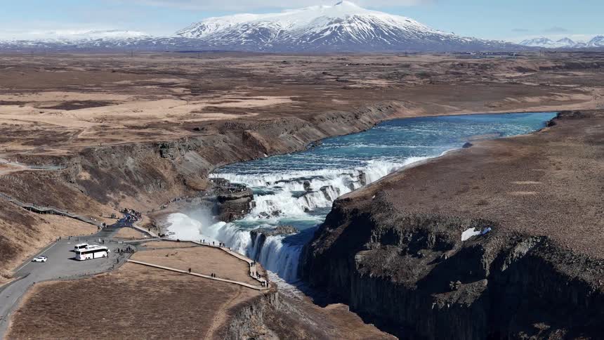 A large river cuts through the land and ends in a waterfall