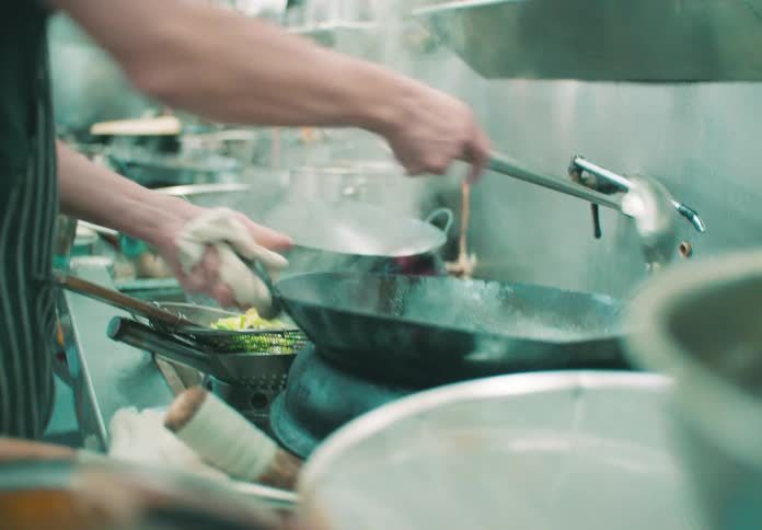 A chef preparing food inside a restaurants kitchen at night
