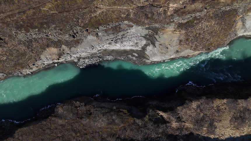 River flows smoothly through a canyon on a bright sunny day