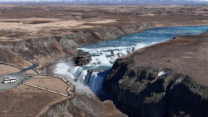 Recreational vehicles are parked by the waterfall