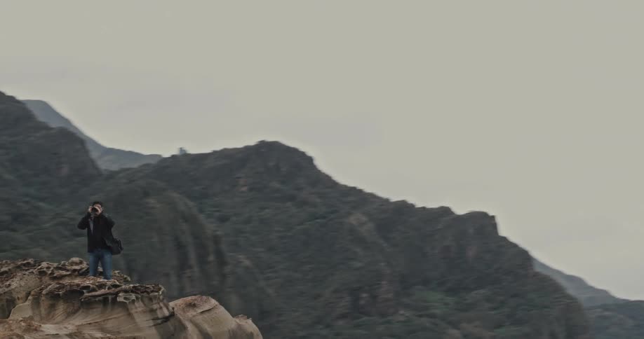 Aerial panorama of a man on a mountain peak with a camera