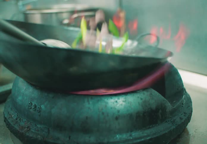 Food being cooked in a frying pan in a restaurant