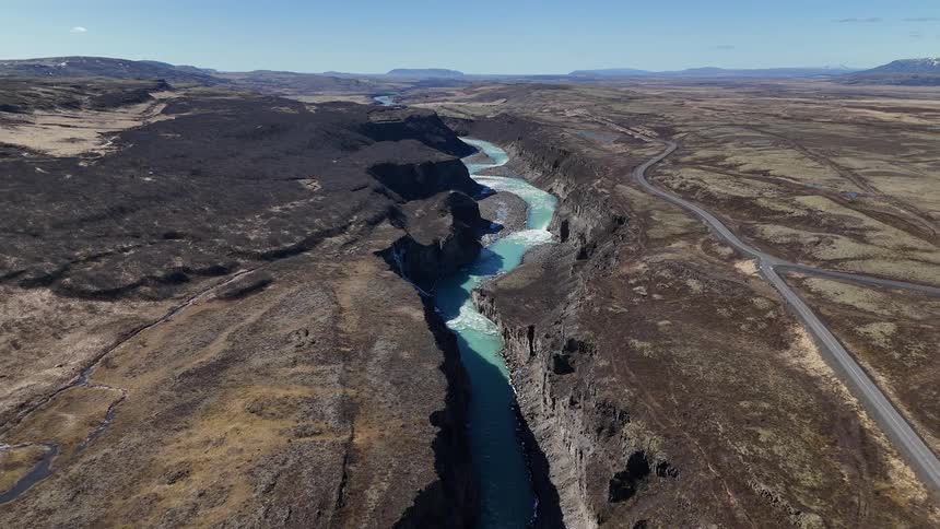 A river has white water as it passes over rocky areas in a canyon