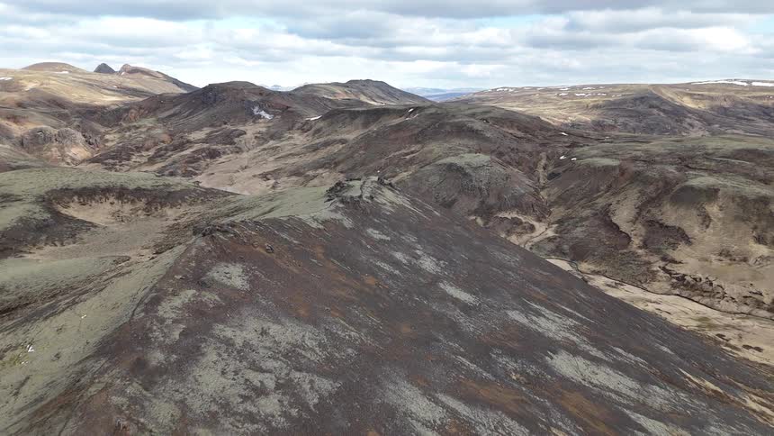 A valley surrounded by a series of mountainous hills at midday