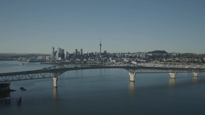 A bridge connecting two cities with cars driving across it at midday