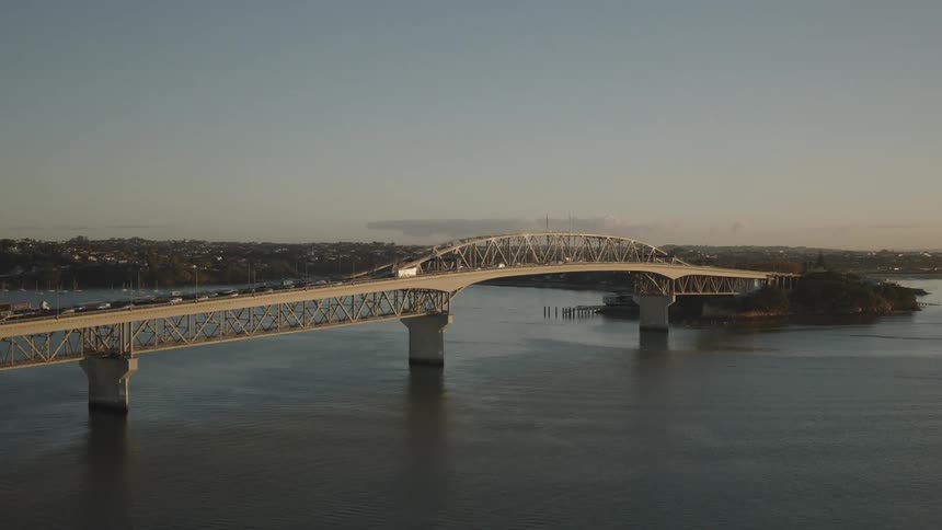 Traffic moves on a bridge over a river in a large urban area
