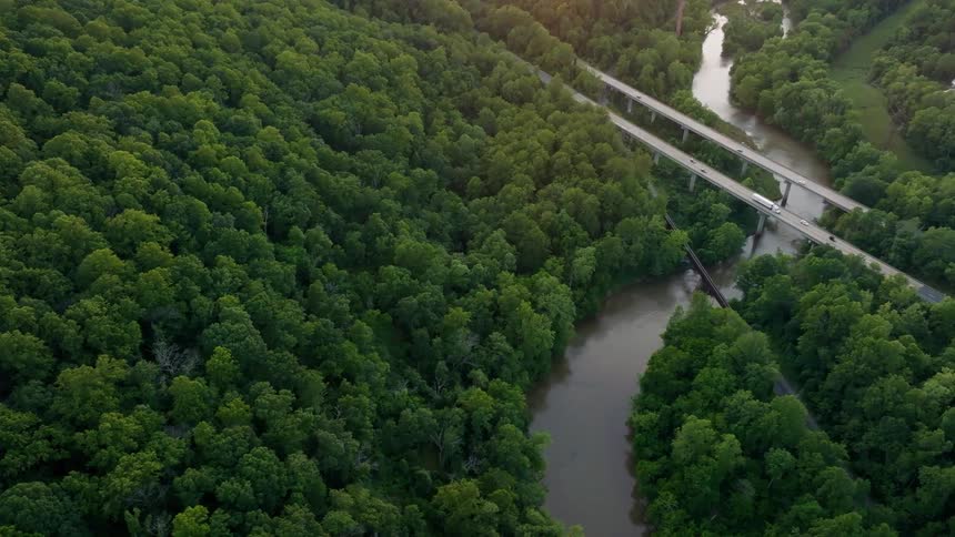 Trucks and cars travel over the bridge on the river