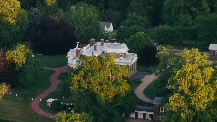 A large manor is surrounded by trees