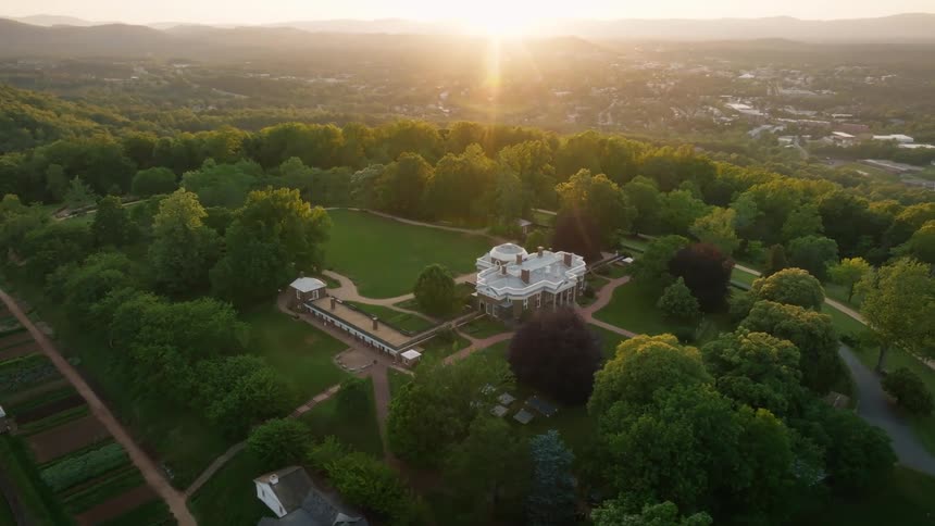 A large house near many trees and lawns with plantations next to it