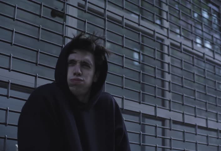 A man gets a chill from the wind and puts up his hood