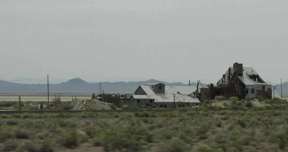 A vehicle drives by an abandoned building