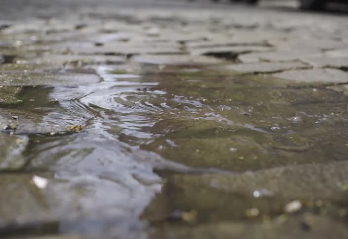 A woman walks through the puddle