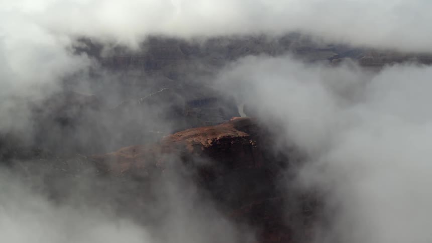 Fog and clouds hang above the mountainous landscape