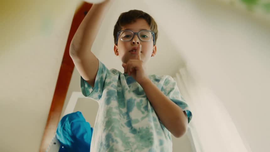 A child shushes someone during a game of hide and seek