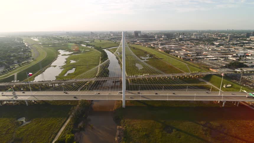 Traffic crosses a bridge over a river that separates parts of a large city