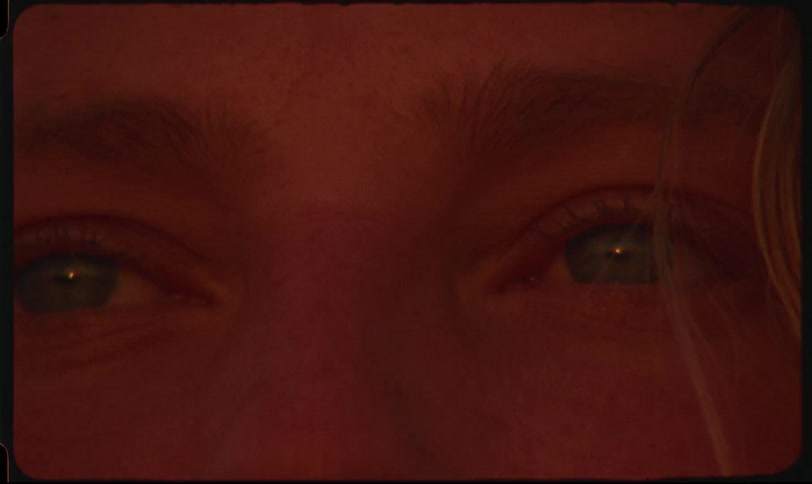 Closeup of a persons eyes opening slowly in warm dramatic lighting