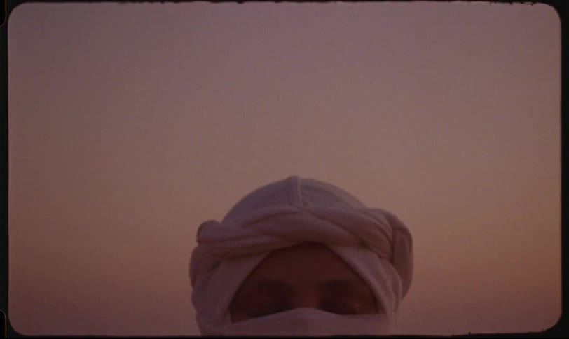A woman wearing a hijab standing with her eyes closed then opening them
