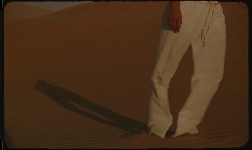 Legs of a woman in white pants on the desert sands