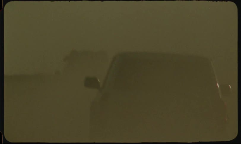 Woman with a headscarf and cars speeding through the desert