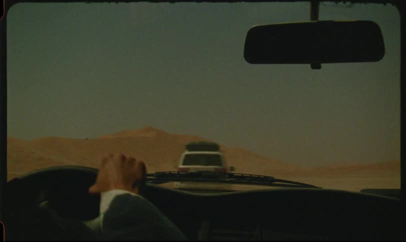 Silhouette of a person driving a car in the desert
