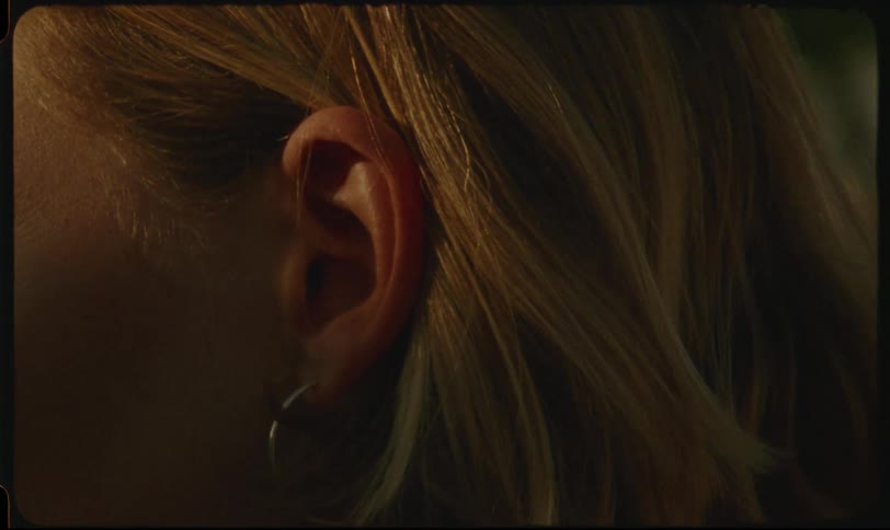 Side portrait of a blonde woman with her ear highlighted with an earring
