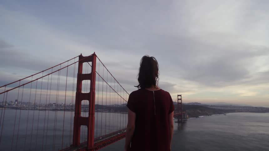 A woman takes in the view of a large bridge