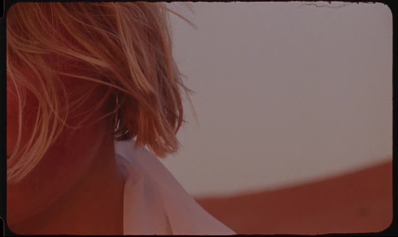 Blonde woman with earrings in an outdoor setting in the desert