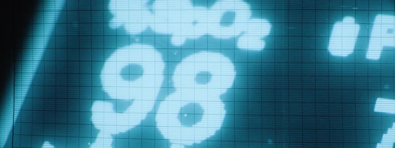 Numbers and information are projected in the dark on the wall