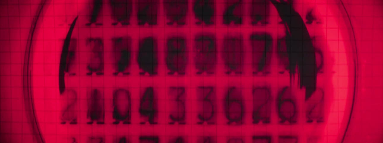 Zooming in on a red screen with numbers being generated on it