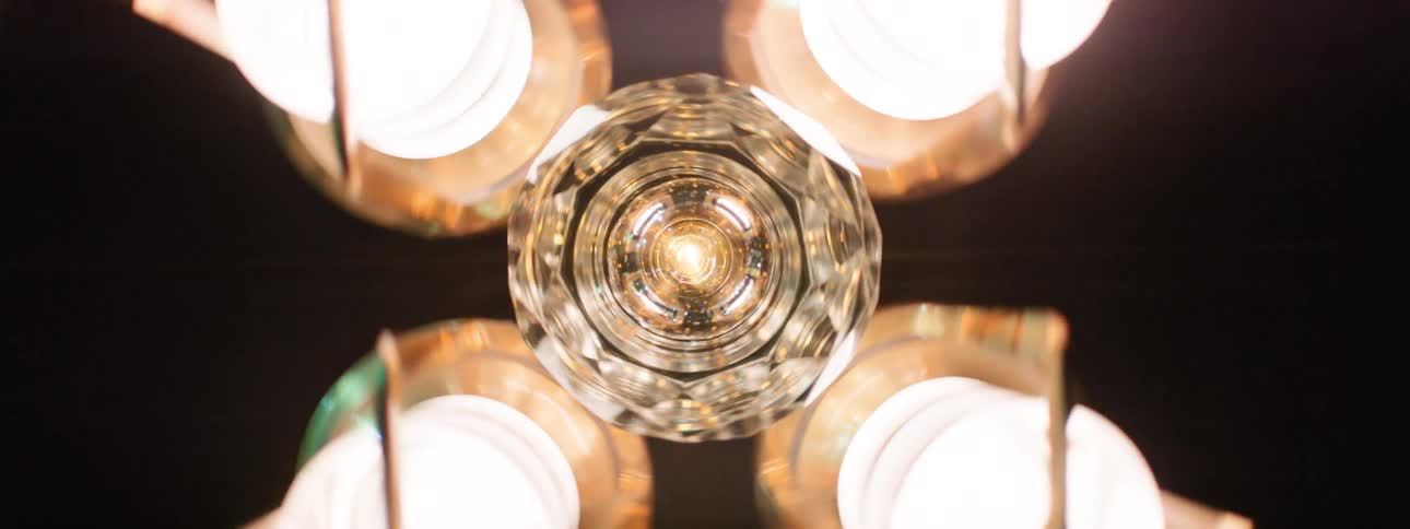A chandelier light spinning 360 degrees on the ceiling casting bright illumination throughout the room