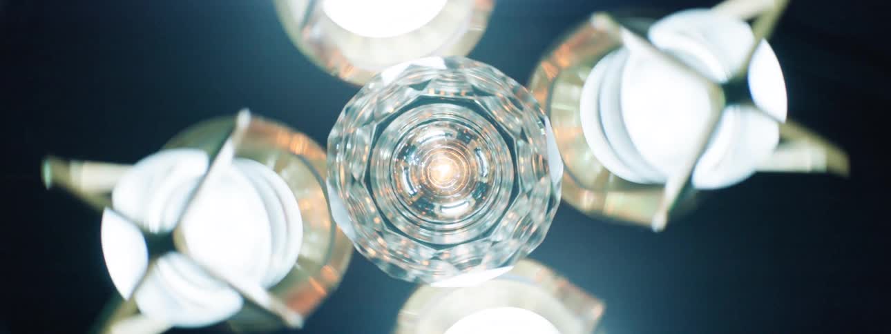 A central multifaceted crystal sphere emits a bright effervescent light surrounded by five symmetrically placed illuminated metallic structures against a dark backdrop